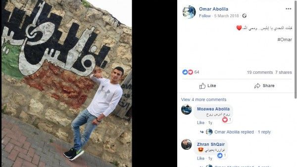 عمر ابو ليلى يقف على جدارية فلسطين.jpg